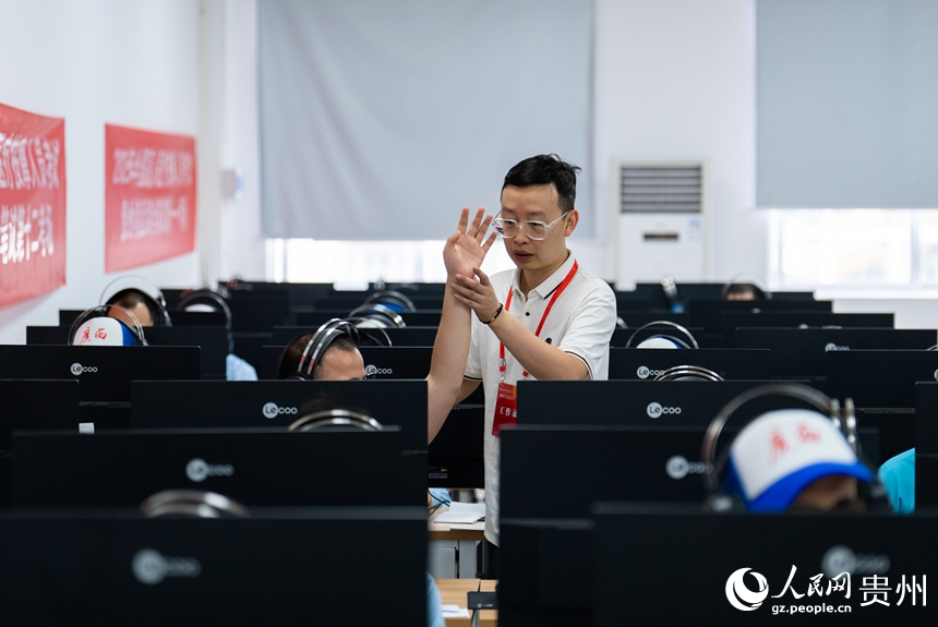 工作人员协助视障考生完成综合笔试。人民网记者 涂敏摄