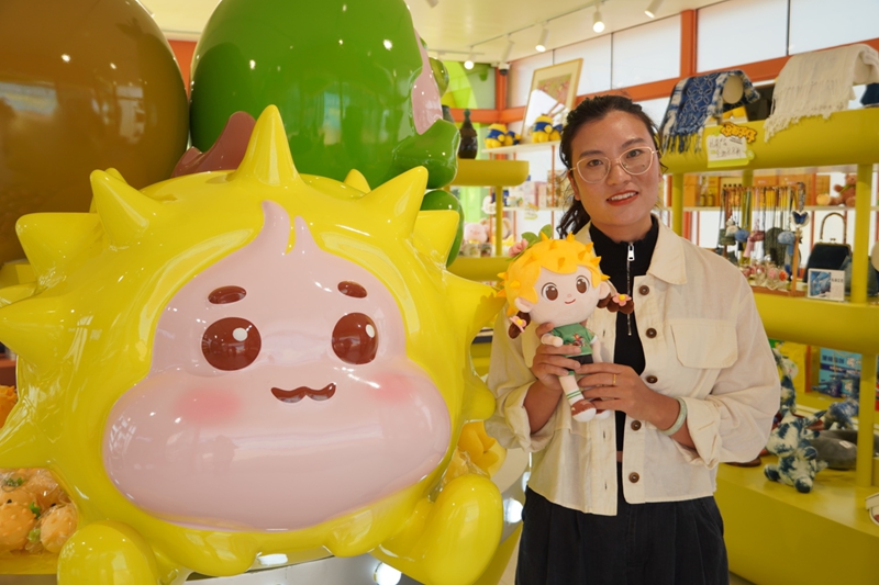 群众与文创产品“刺小妮”合影。李佳琪摄