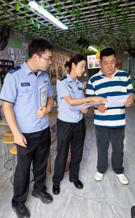 輔警向轄區群眾發放文明養犬宣傳資料。