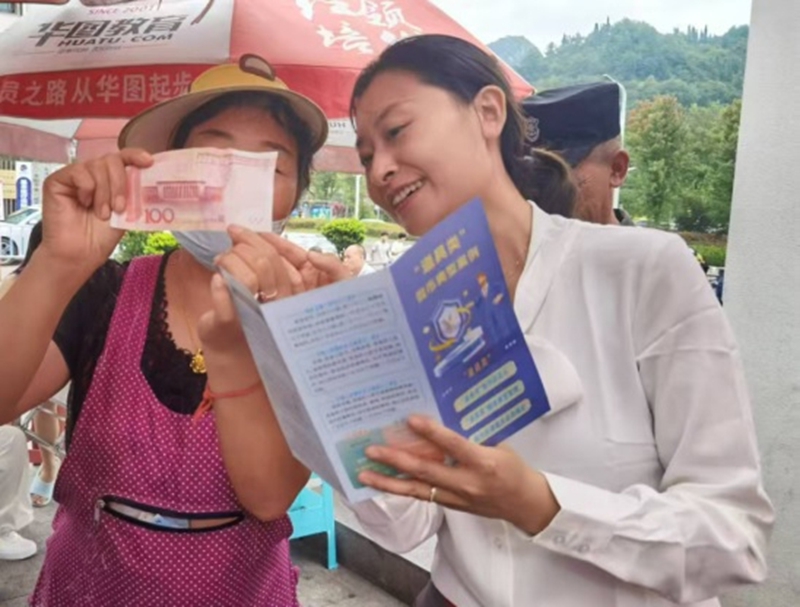 宣傳員手把手教商戶掌握人民幣防偽特征和假幣識別技巧。