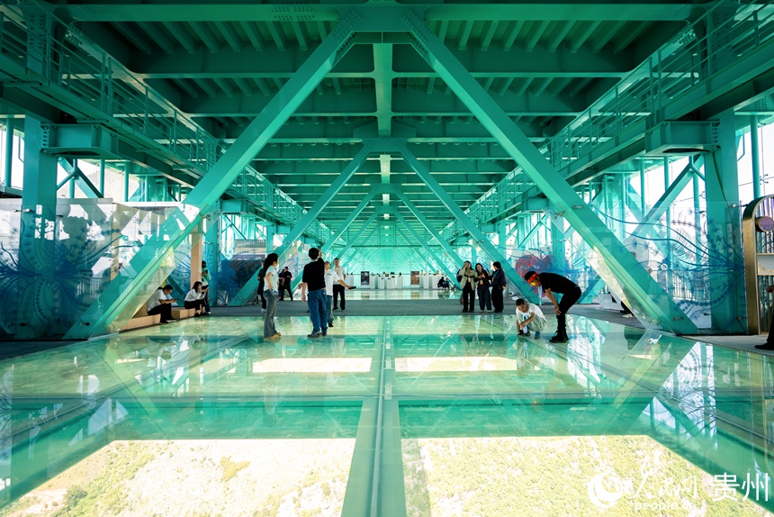 参观者在花江峡谷大桥中部的玻璃观光厅体验独特的观景视角。人民网记者 涂敏摄