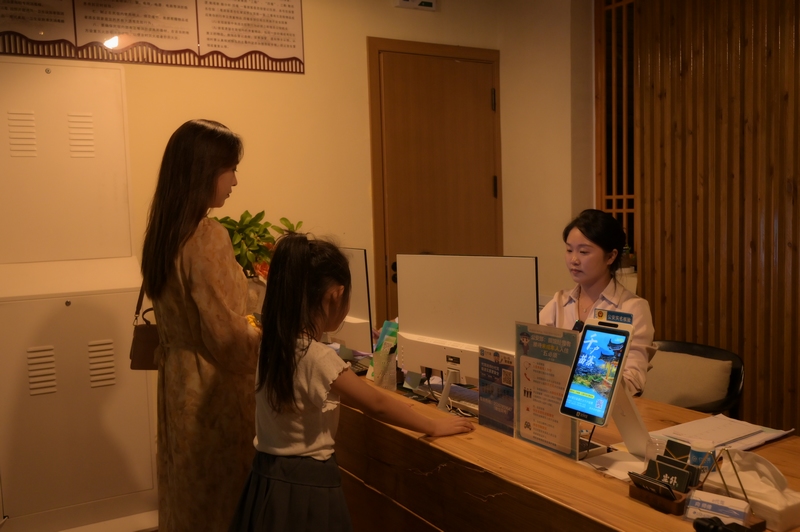 在仁懷市長崗鎮藺田村塵外楠山民宿接待大廳，游客正在辦理入住。