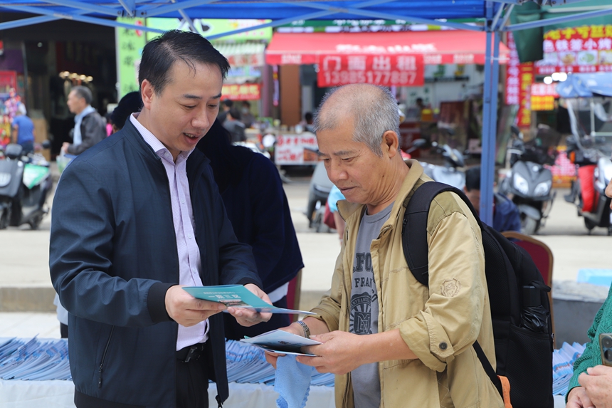 贵州省文化和旅游厅工作人员正向游客详细讲解《旅游安全实务手册》中的应急避险知识。