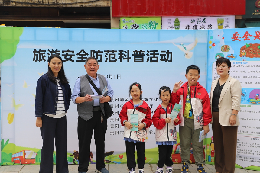 贵州师范学院旅游文化学院老师（左一）与贵阳市市公共卫生救治中心工作人员（右一）在完成科普讲解后，同受益游客合影留念。