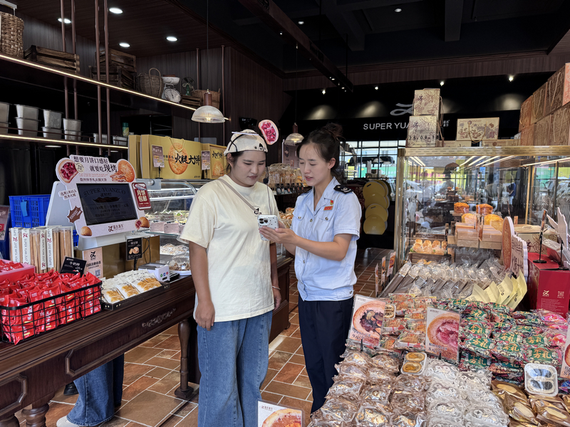 圖為 稅務干部指導納稅人使用電子稅務局APP開具發票。李娜莎攝