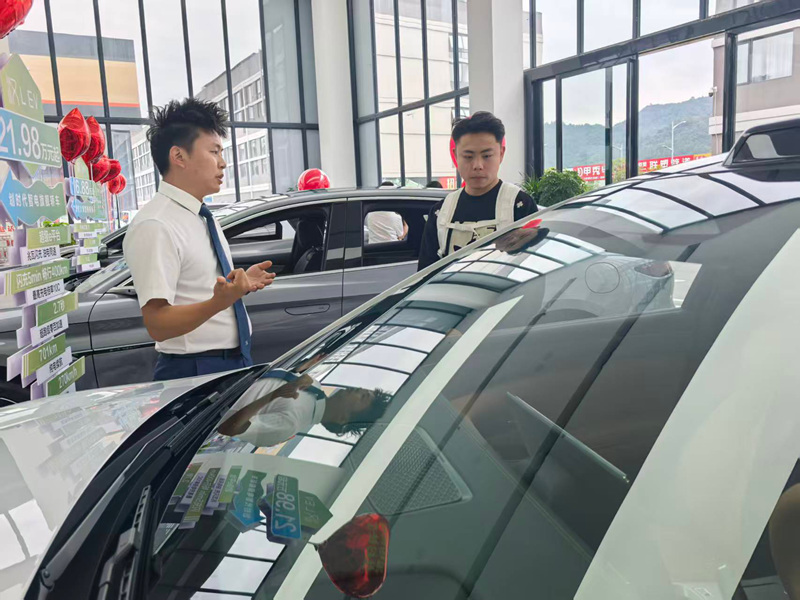 销售顾问正在给顾客介绍车子的性能。