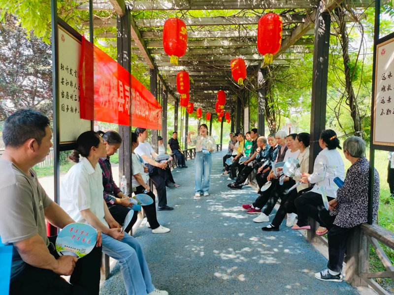 在松坎镇新时代文明实践广场法治文化长廊，县司法局“专业说法”宣讲队成员谢红霞正在为该镇茅坝社区居民开展普法宣传。