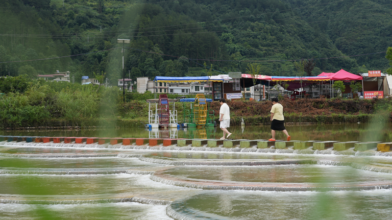 游客行走在龙里县龙山镇余下村鱼麟坝。