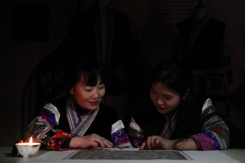 织金县蔡群苗族蜡染刺绣有限公司总经理蔡群指导绣娘制作蜡染工艺品