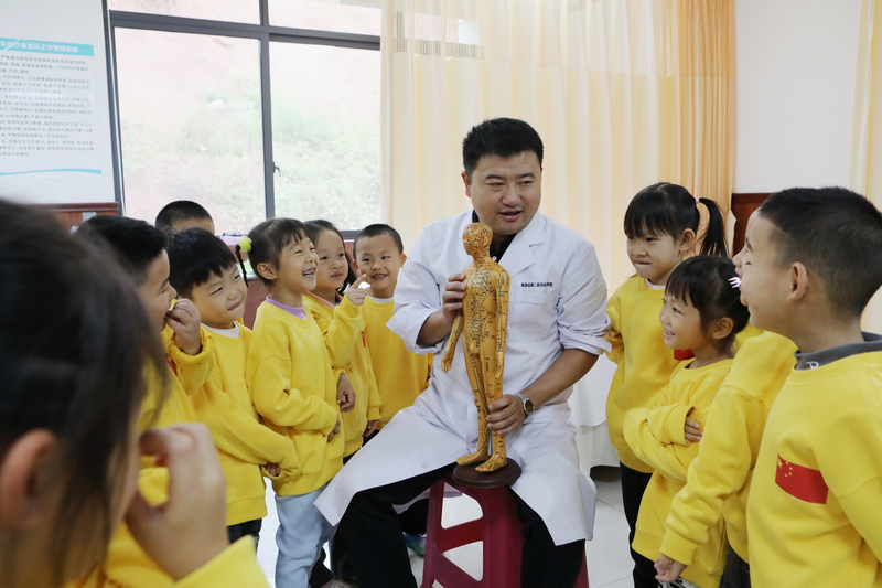 贵州省黔东南苗族侗族自治州施秉县民族中医院的医生向县第二幼儿园的小朋友们讲解中医药知识。
