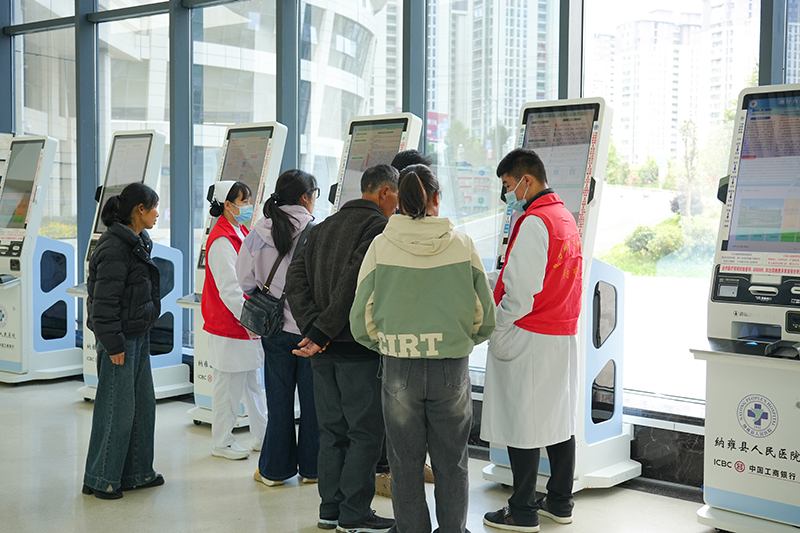 導診護士指導群眾操作自助挂號機挂號就診。胡璐攝
