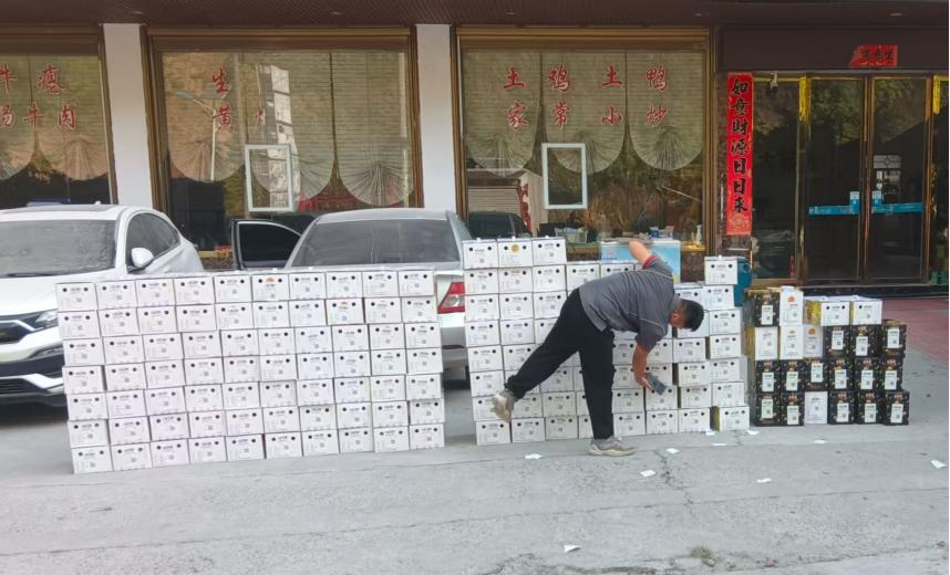 快遞員將領襪村百香果裝箱。