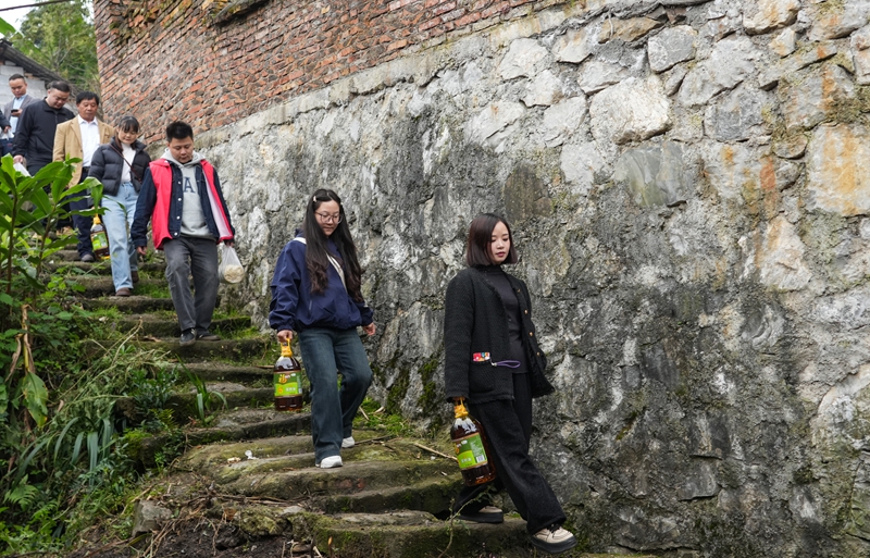 2025年10月29日,贵州省毕节市纳雍县文昌街道珙桐社区,志愿者给行动不便的老年人送物资。 杨英摄