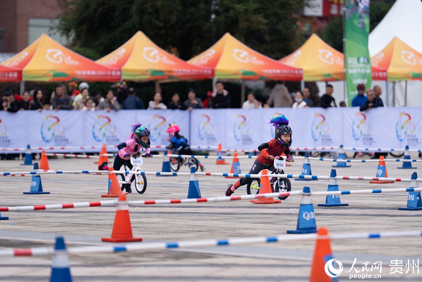 儿童滑步车项目比赛现场,小运动员在场地内展开激烈的追逐。人民网记者 涂敏摄