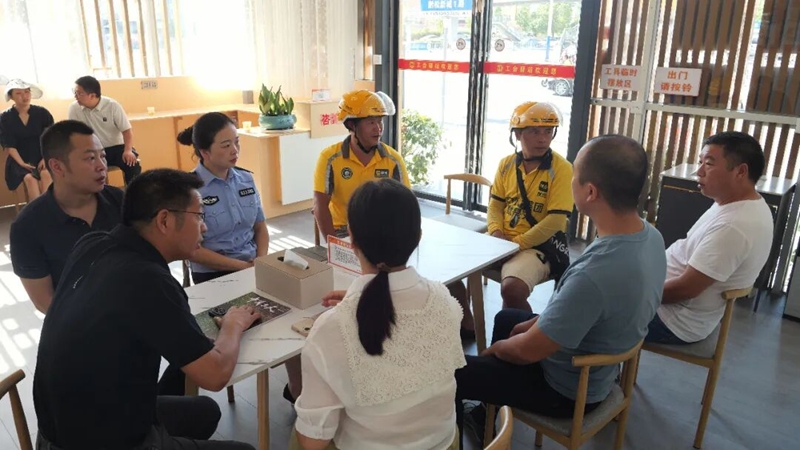 相关工作人员听外卖骑手建议。