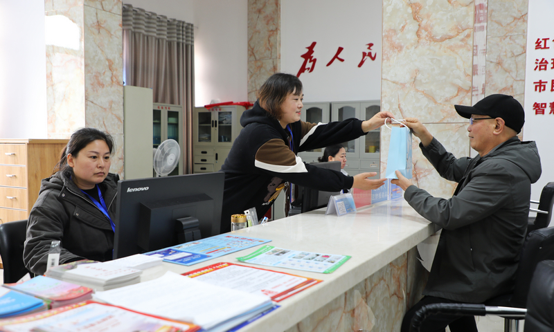 社区干部为老人提供服务。