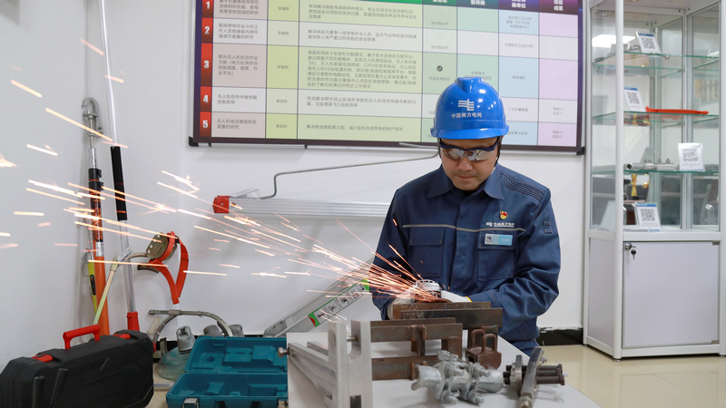 nEO_IMG_南方电网贵州兴义供电局输电管理所综合数据班高级作业员龙福刚研发安全工具器，确保同事们安安全全地工作，更好地护航电网安全稳定运行。卢关文摄