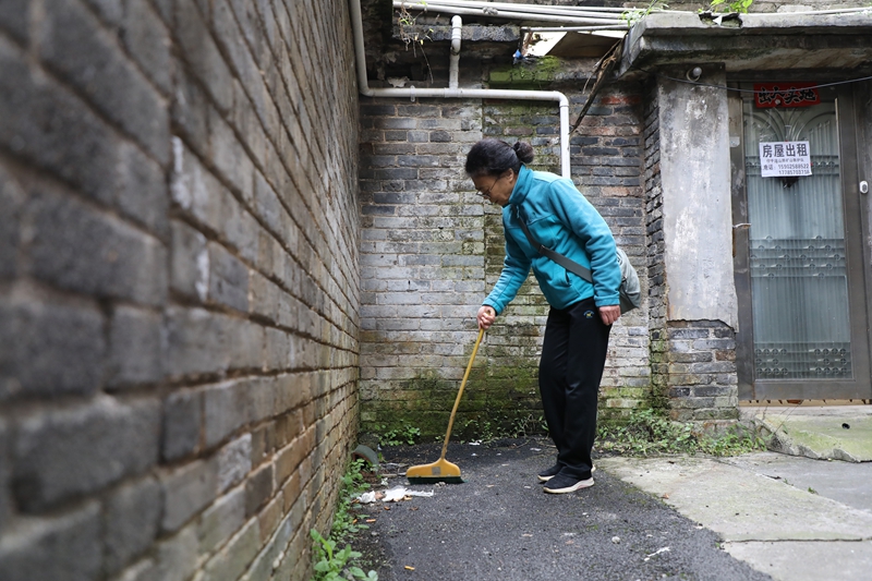 七星關區洪山街道洪山社區老舊小區改造后環境干淨整潔，居民正在打掃衛生。邱夢如攝