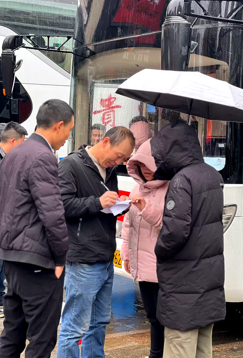 “春风行动”活动现场，工作人员确认务工群众乘车名单。习水县融媒体中心供图