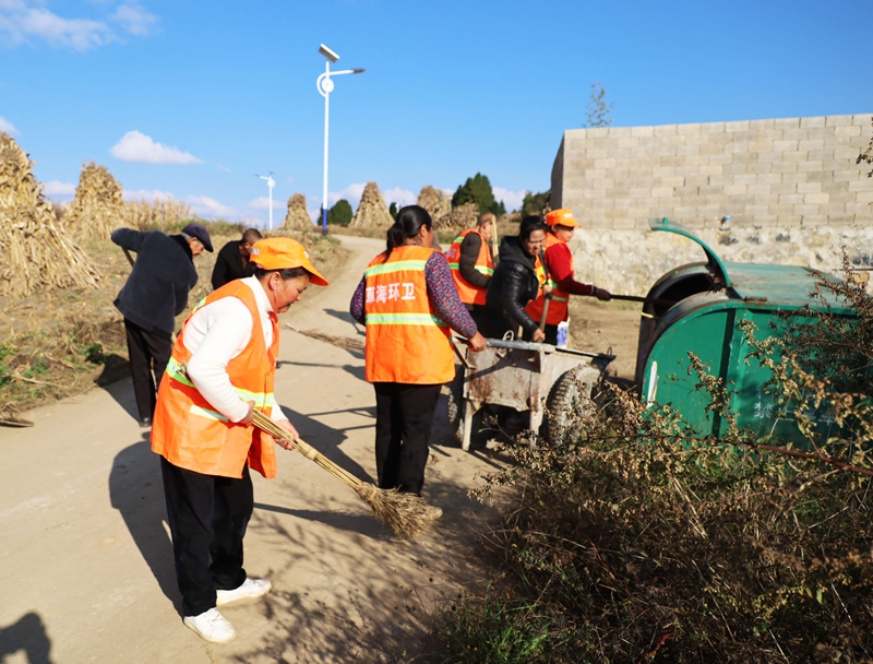 郑家营村保洁员和群众正在打扫进村公路。