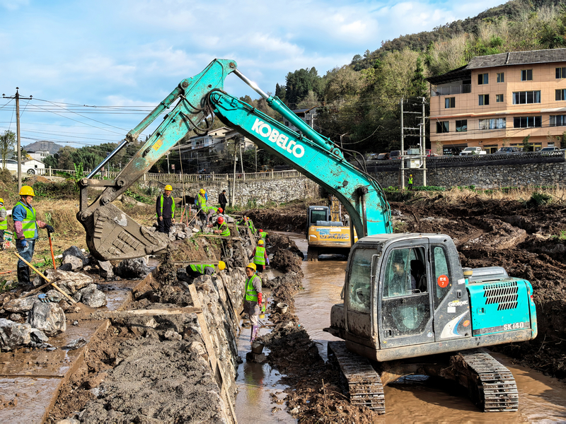 茅石镇镇龙村的河堤治理工地上,村民们正仔细夯实着碎石层。王琨荣摄