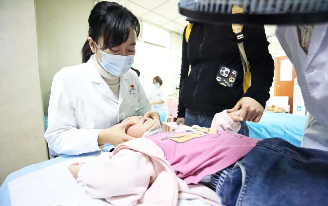 冷丽正专注地为患儿进行推拿。