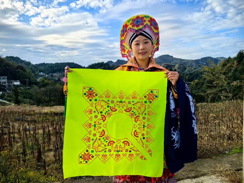 马学珍拿着刚绣的作品。杨洋 摄.jpg