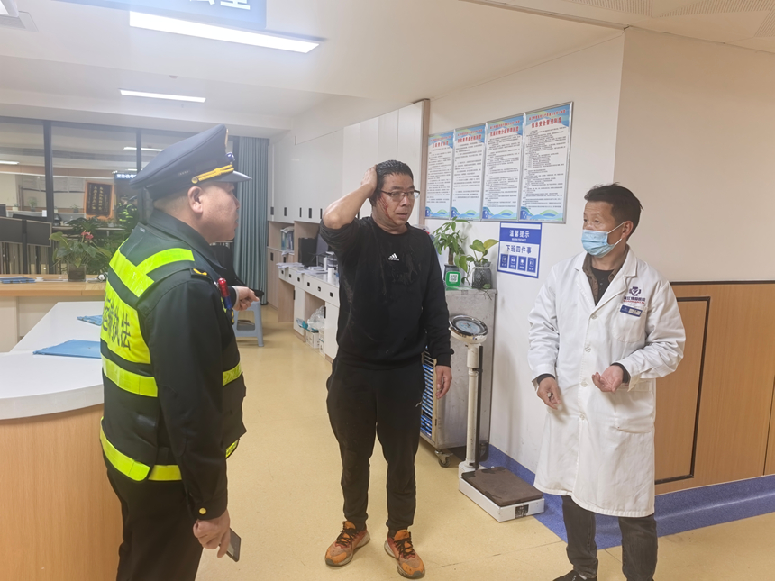 图为执法人员将驾驶员送到医院。