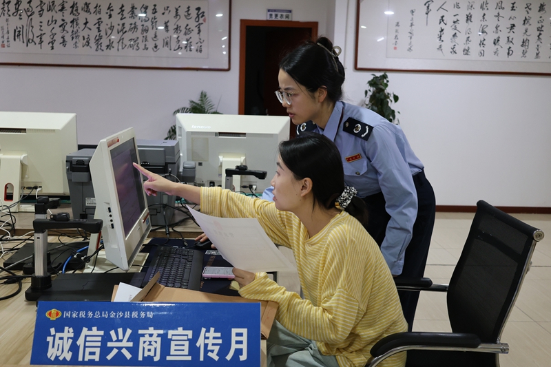 金沙縣稅務局辦稅服務廳內，稅務干部在向納稅人納稅信用評價標准與信用修復機制。助力誠信社會建設。顧拾金攝