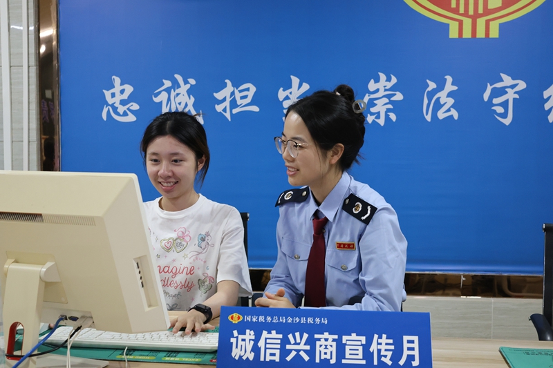 金沙县税务局办税服务厅内,税务干部在向办事群众向纳税人缴费人普及诚信经营、依法纳税、消费者权益保护等知识。顾拾金摄
