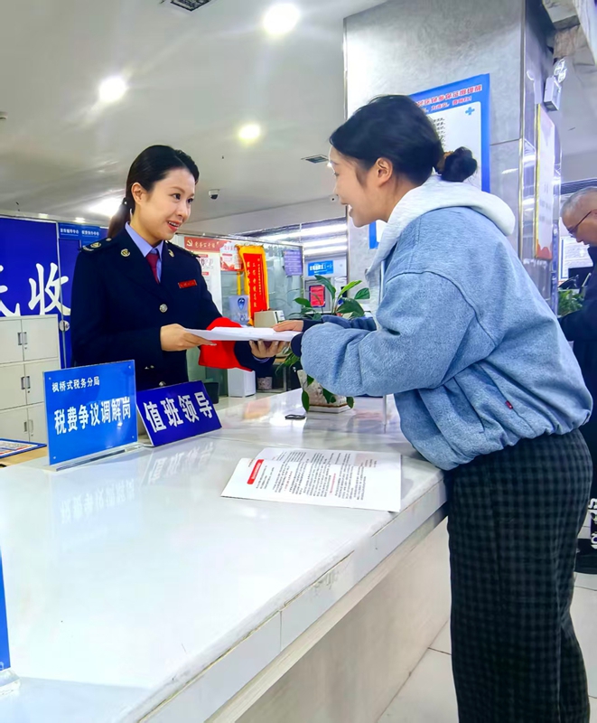 税务干部为纳税人办结税务事项并讲解相关税费优惠政策。童霖摄