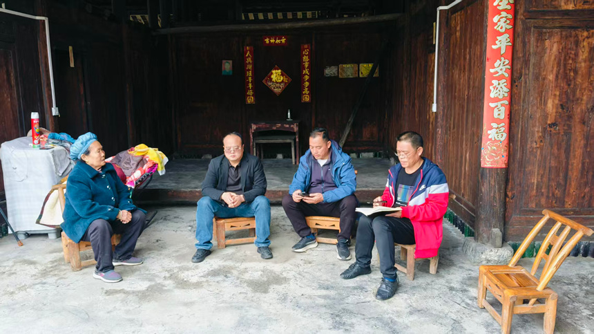 松桃鸡爪社区驻村干部、村干部上门送医保政策。