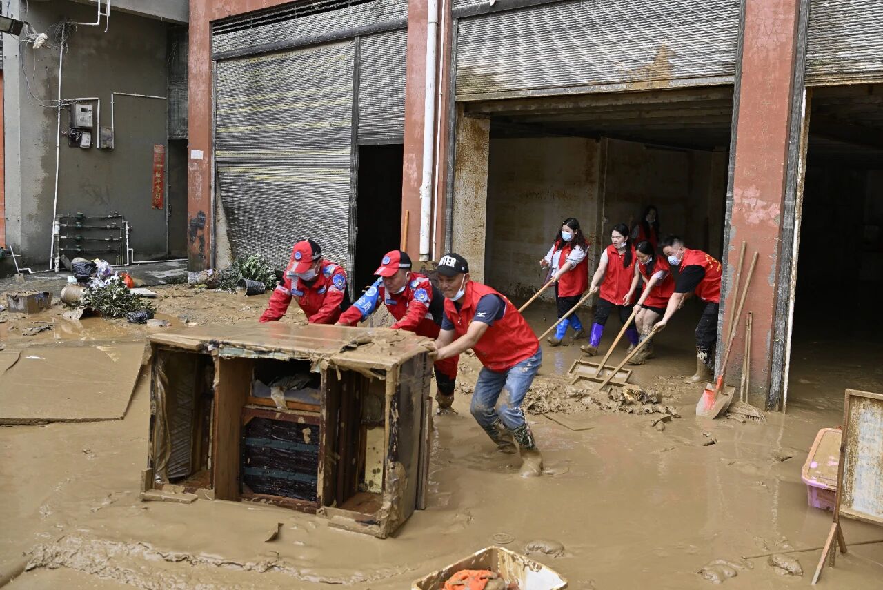 图为应急人员在榕江县城内一居民区搬运被水泡坏的物件。陈沛亮摄