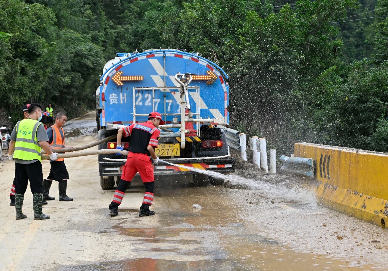 图为应急突击队在国道321线清理路面淤泥。陈沛亮摄