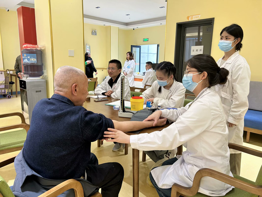 医护人员给老人做血压监测。罗金摄