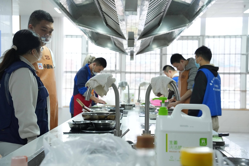 在志愿者帮助下，孩子们在“爱心厨房”尝试参与力所能及的劳动训练。杨菁驰摄