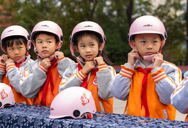 民警教学生正确佩戴头盔。