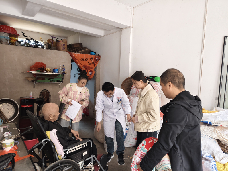 工作人員正在為梁承鬆老人做“上門評殘”工作。