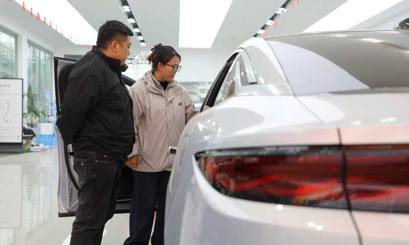 不少消费者或围在展车旁细致查看车辆配置，或坐进驾驶舱体验空间舒适度 。陈桂良摄