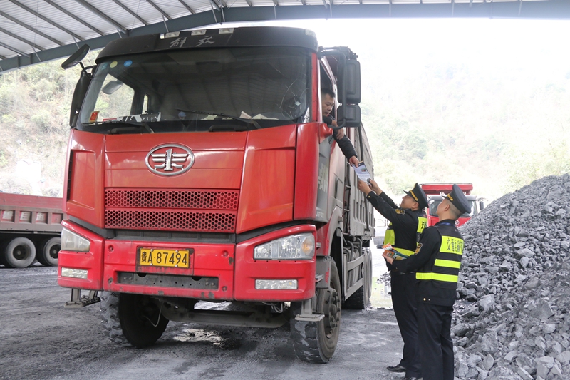 执法人员在矿区向司机发放普法宣传册。