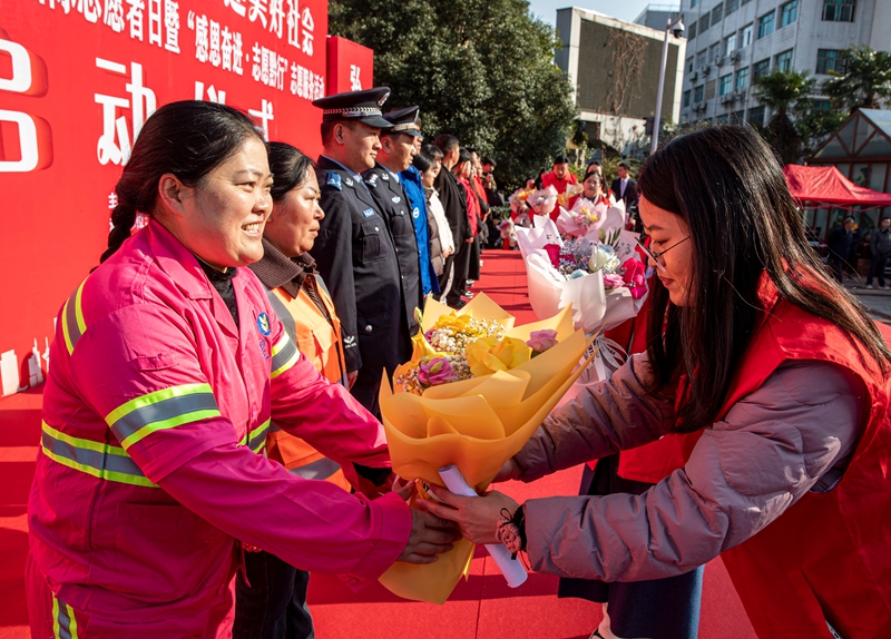 2025年12月5日，贵州省黔西市纪念第40个国际志愿者日主题志愿服务活动现场，志愿者为该市各领域的志愿者代表献花。B62I8017