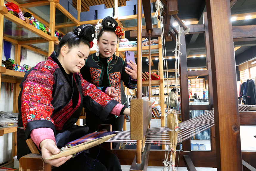 在贵州省黔东南苗族侗族自治州施秉县一家非遗就业工坊，主播在直播推销苗族纺织产品。