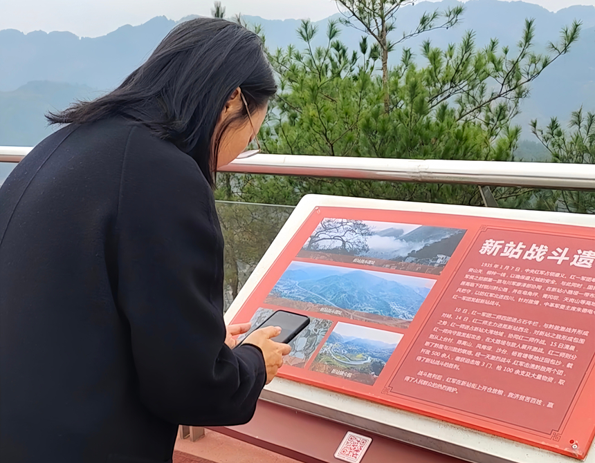 大娄山服务区内,游客在红色步道上扫码聆听红色故事。实习生 黄小妹摄