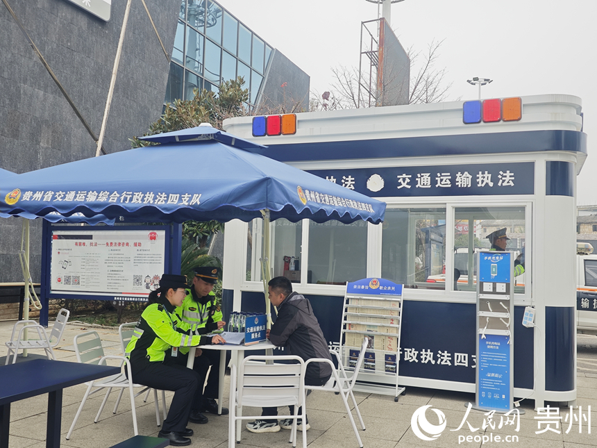 龙宫服务区内,司乘人员在交通运输执法服务点进行咨询。人民网 黄小桃摄