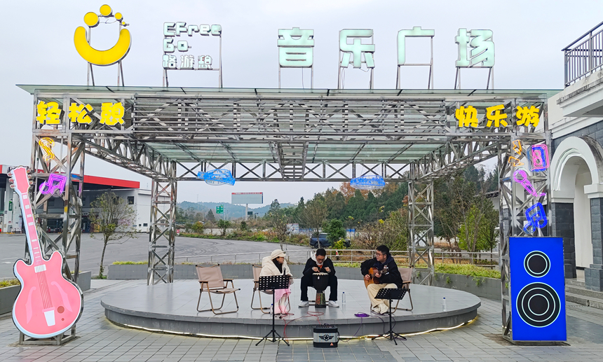正安服务区内,游客在音乐广场弹唱。实习生 黄小妹摄
