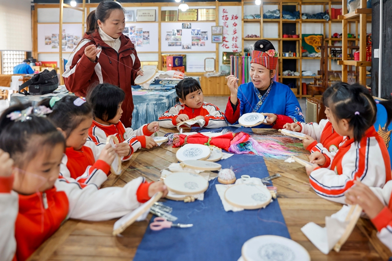 2025年12月10日，贵州省黔东南苗族侗族自治州施秉县第四幼儿园的孩子们在非遗代表性传承人的指导下体验苗绣技艺。