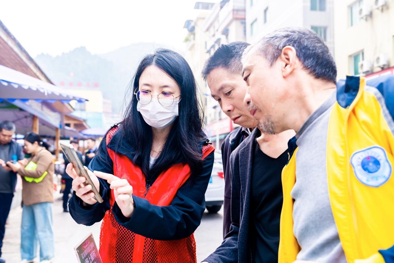 图为志愿者向群众演示“码上服务”功能.jpg