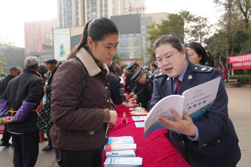 稅務干部在服務台前為群眾面對面解答疑問。李琪攝