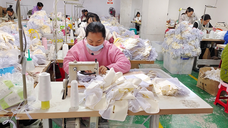 工人们正紧张有序地加工各式各样的服饰 (4).jpg