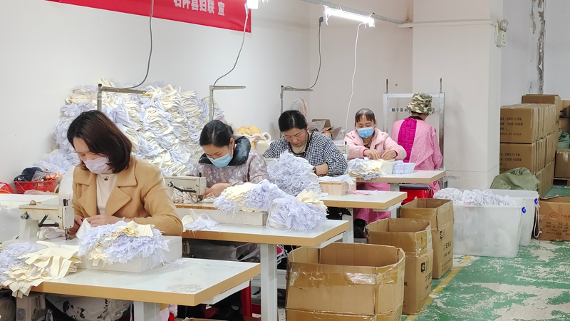 工人们正紧张有序地加工各式各样的服饰。